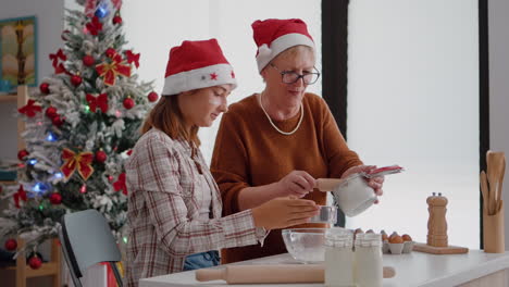 grandmother putting flour ingredients in strainer explaining to granddaughter