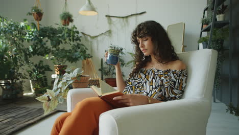 woman reading book and drinking tea at home