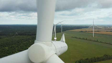 close up of a rotating wind turbine with wind turbine park in the background