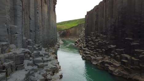 Deep-river-valley-with-majestic-geology-formation-in-Iceland,-aerial-drone-view