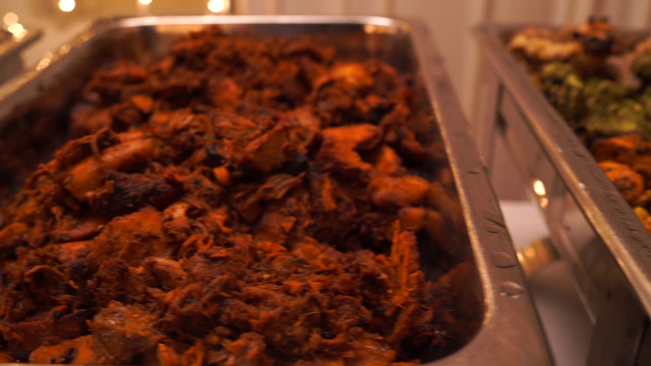 chef de pie detrás de la estación de servicio de almuerzo completo con una variedad de alimentos en bandejas