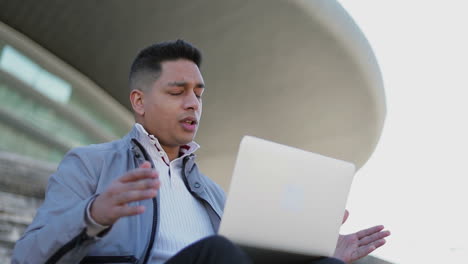 Upset-middle-eastern-businessman-closing-laptop-outdoor