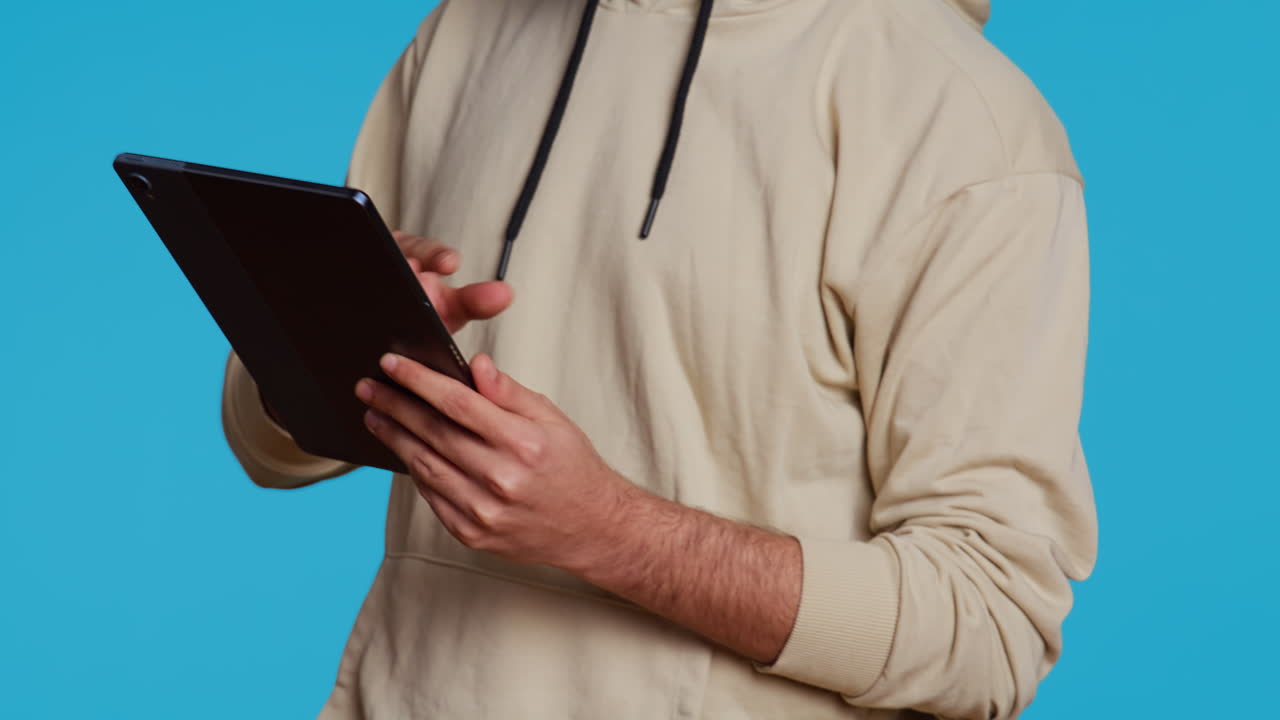 un tipo árabe que usa una tableta para desplazarse por los sitios web en línea