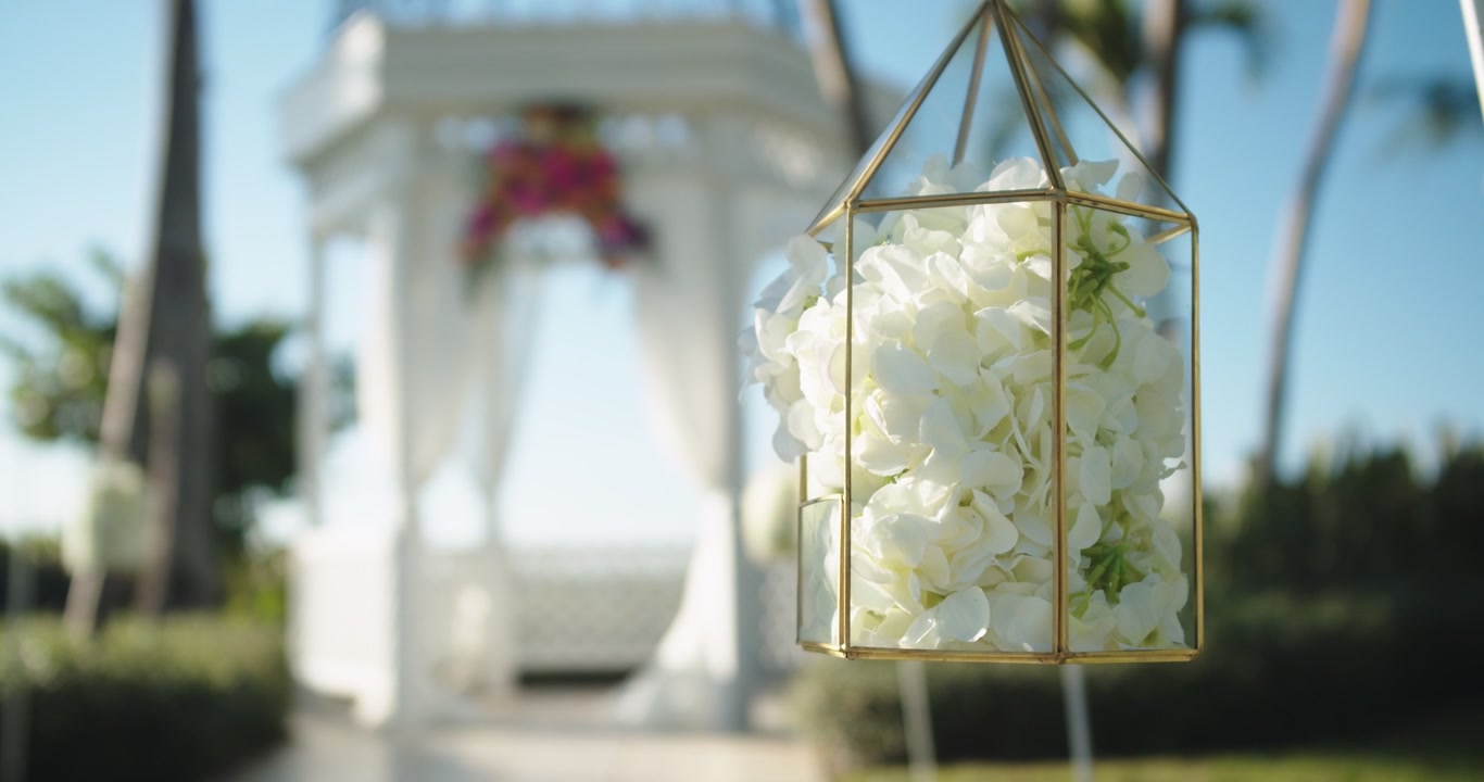 Bella inquadratura statica di matrimonio di fiori appesi davanti a un gazebo.