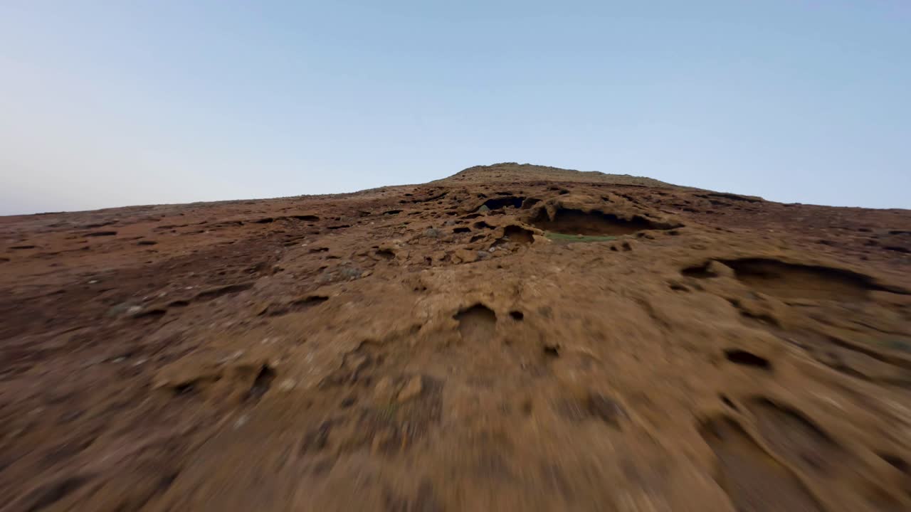 fuerteventura paisaje fpv rocky vulcan mountain rise con vista sobre la ciudad de la costa este en cámara lenta
