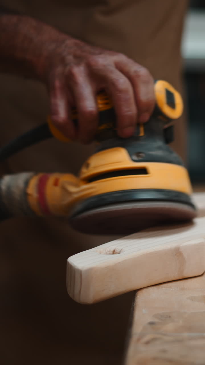 Close-Up of Hand Sanding Wood with an Orbital Sander