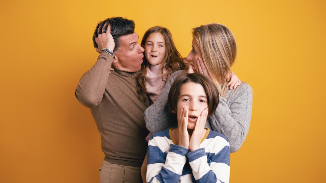 Familia expresando sorpresa e incredulidad sobre fondo de estudio amarillo