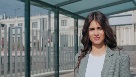 young woman standing at a bus stop in the city
