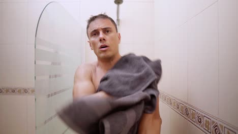 man drying himself with a towel after a shower in the bathroom