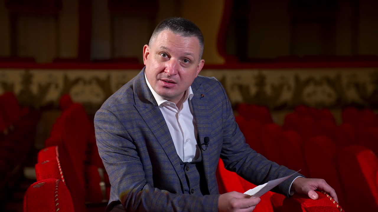 New normal in cinema theater. Portrait of man speaking on camera at theater after pandemic