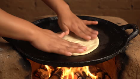 making flatbreads on a traditional griddle over fire