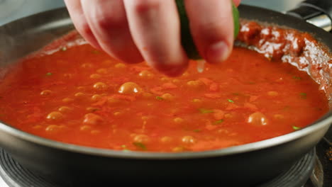 chicken in tomato sauce is boiling on a frying pan with spices. cooking tomato sauce curry with chicken fillet. traditional italian mexican asian dish. high quality studio shot for cafe, restaurant close up.