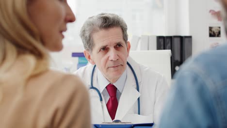 vista de mano de una pareja hablando con un médico en el consultorio del médico