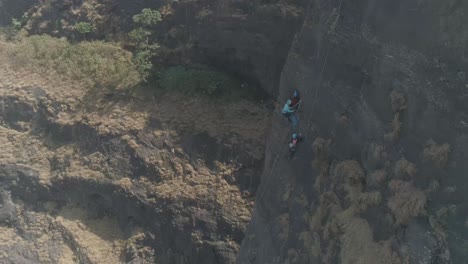 Aerial-shot-of-a-group-of-people-climbing-together-a-beautiful-pinnacle