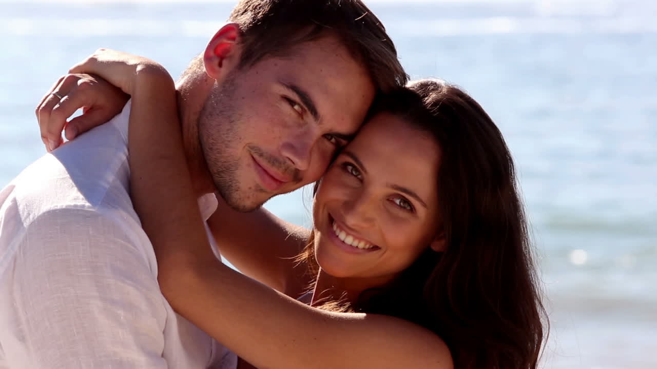 una pareja sonriente abrazándose