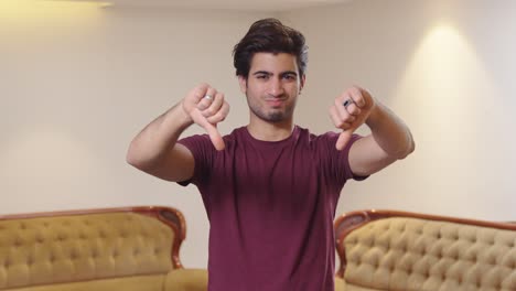 upset indian man showing thumbs down