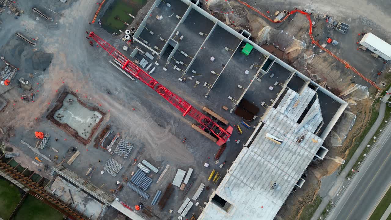 antena superior hacia abajo de una gran grúa de rastreo levantada en el sitio de construcción después de horas