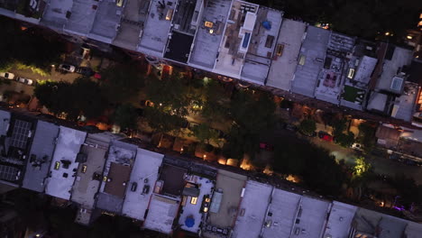 aerial view looking down at a row of brownstones on manhattan's upper west side at night. shot in new york city in 4k.