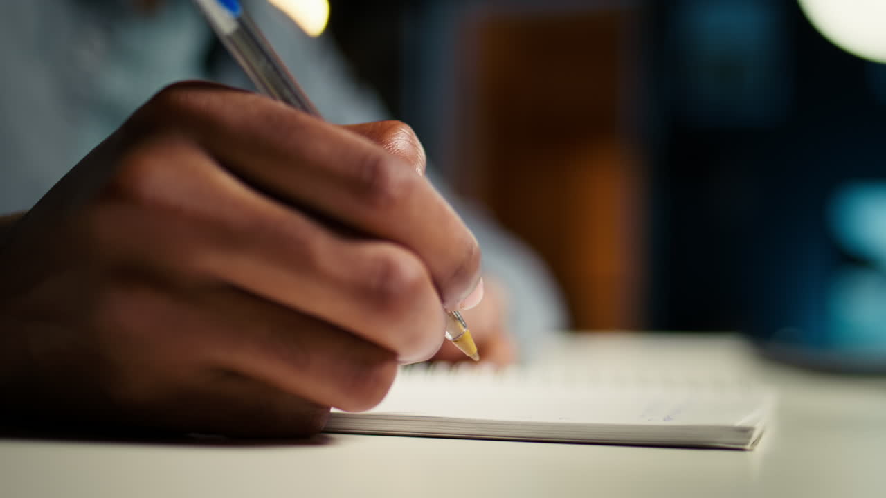 African American person working remotely and drafting project notes