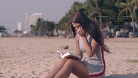 chica en vestido de verano gris con rayas rojas y blancas en la arena