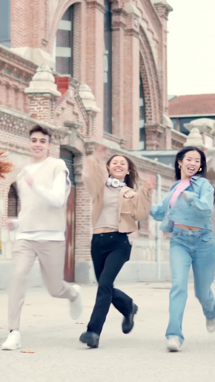 Multiethnic friends laughing and jumping in the street