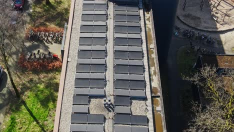 Drone-flying-low-over-photovoltaic-solar-panels-on-top-of-apartment-building