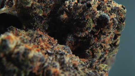 a vertical macro cinematic detailed shot of a cannabis plant, hybrid strains, indica and sativa ,inside the marijuana flower, on a 360 rotating stand, slow motion, 4k video, studio lighting