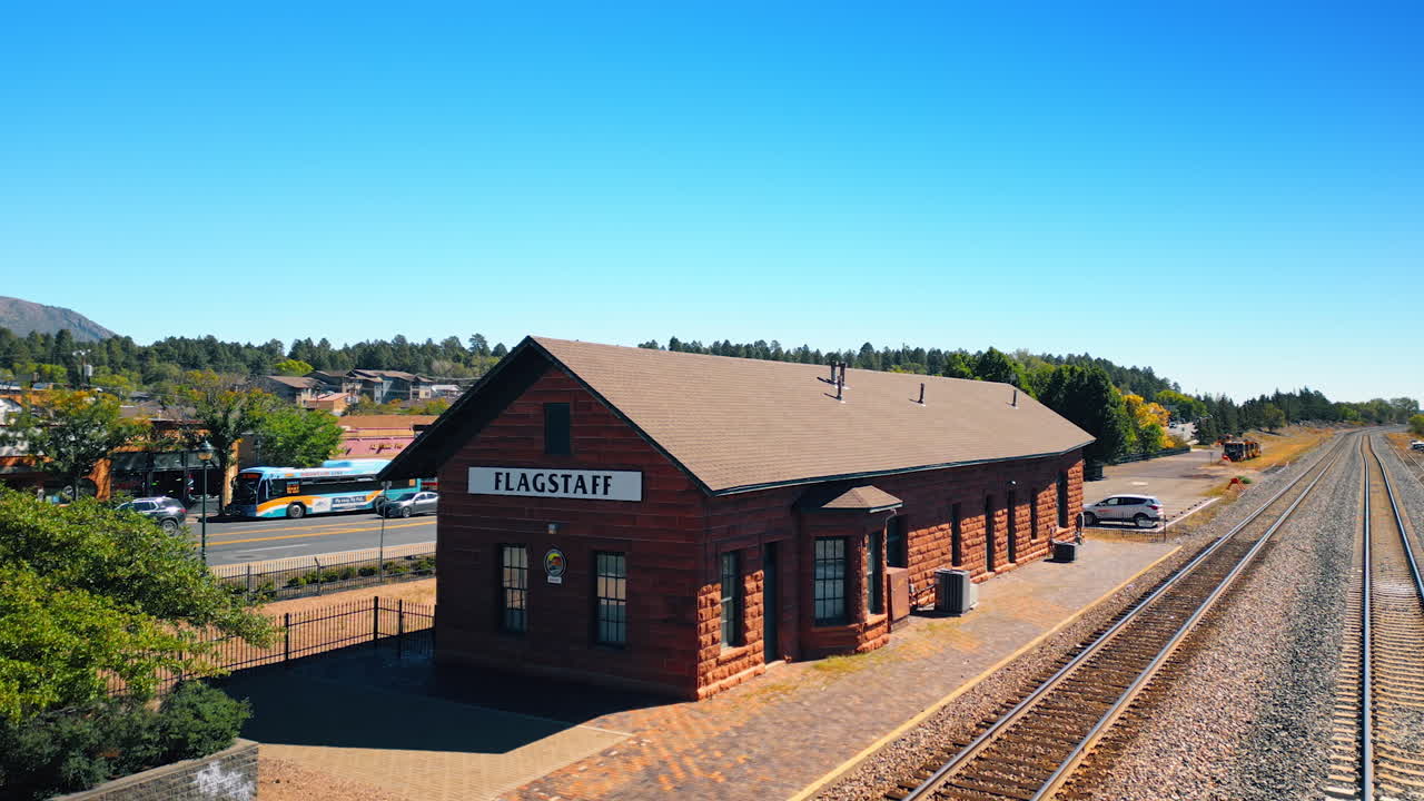 Flagstaff, USA, 24 August 2025: One-storied building of a railway station in Flagstaff, Arizona, USA. A highway and green residential area at backdrop