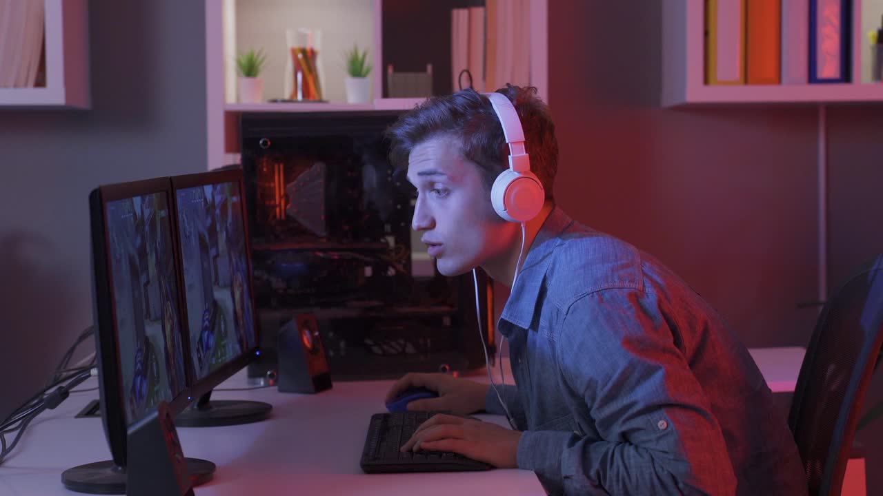 흥미진진한 게임을 하고 컴퓨터로 온라인 비디오 게임을 하는 젊은이.