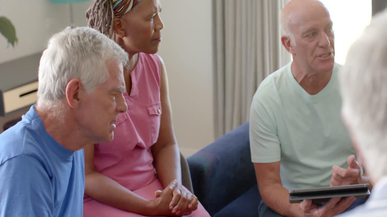 varios ancianos escuchando a un terapeuta masculino en una sesión de terapia de grupo, sin alteración, en cámara lenta.