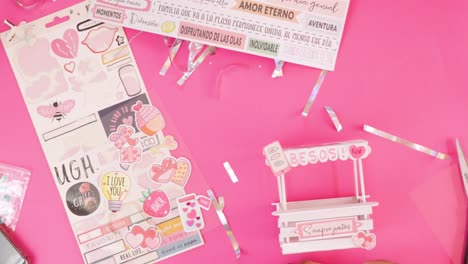 putting stickers on miniature kissing booth made from popsicle sticks.