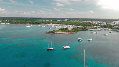 drone flying over luxury boats moored in tropical waters of bayahibe tourist port, la romana in dominican republic