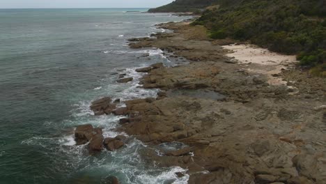 playa rocosa aérea de 4k del sur de australia - dron sobre la cabeza + carro en tiro