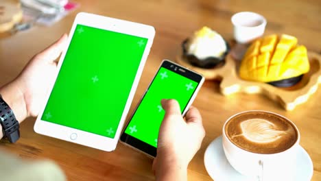manos usando un teléfono inteligente con pantalla verde