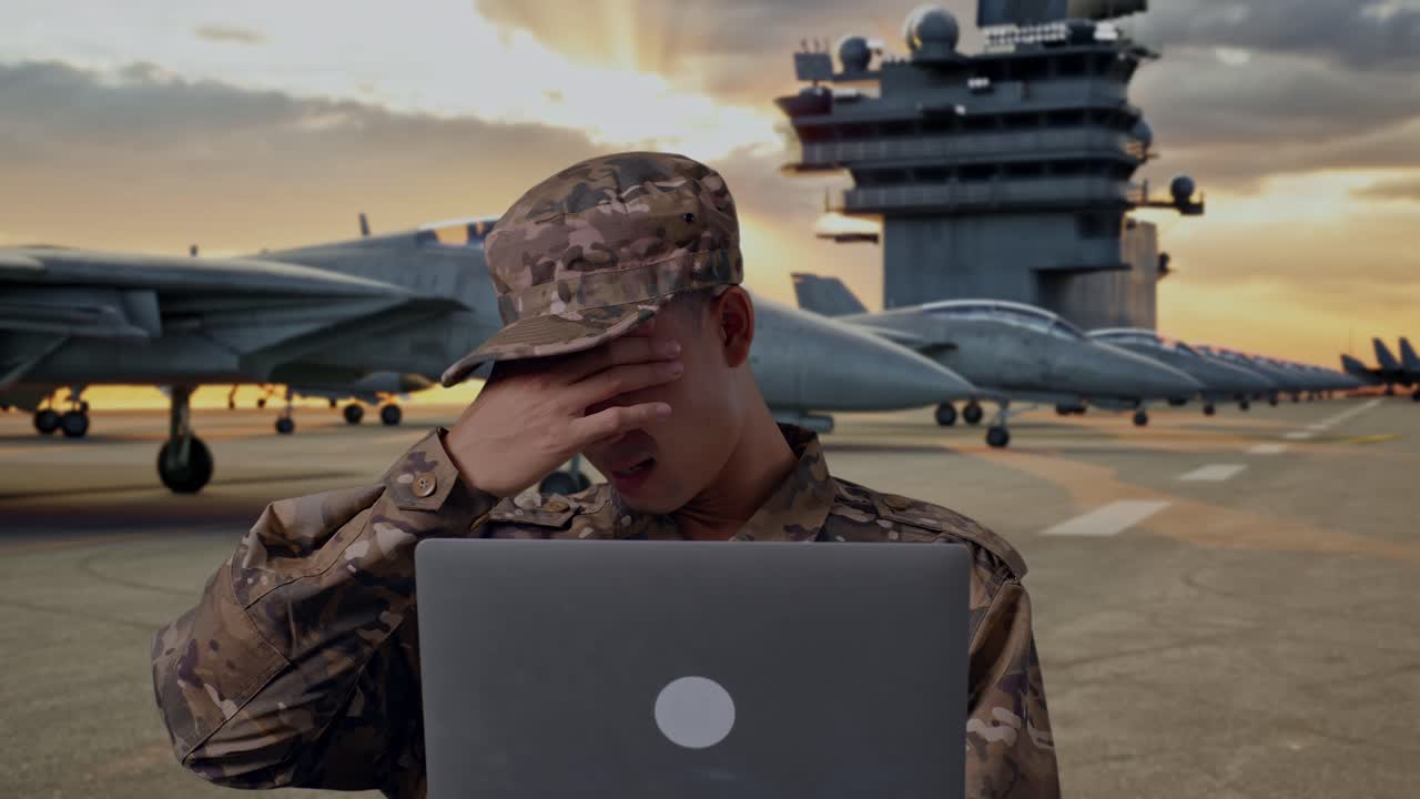 Stressed Military Personnel Working on Laptop at Naval Base