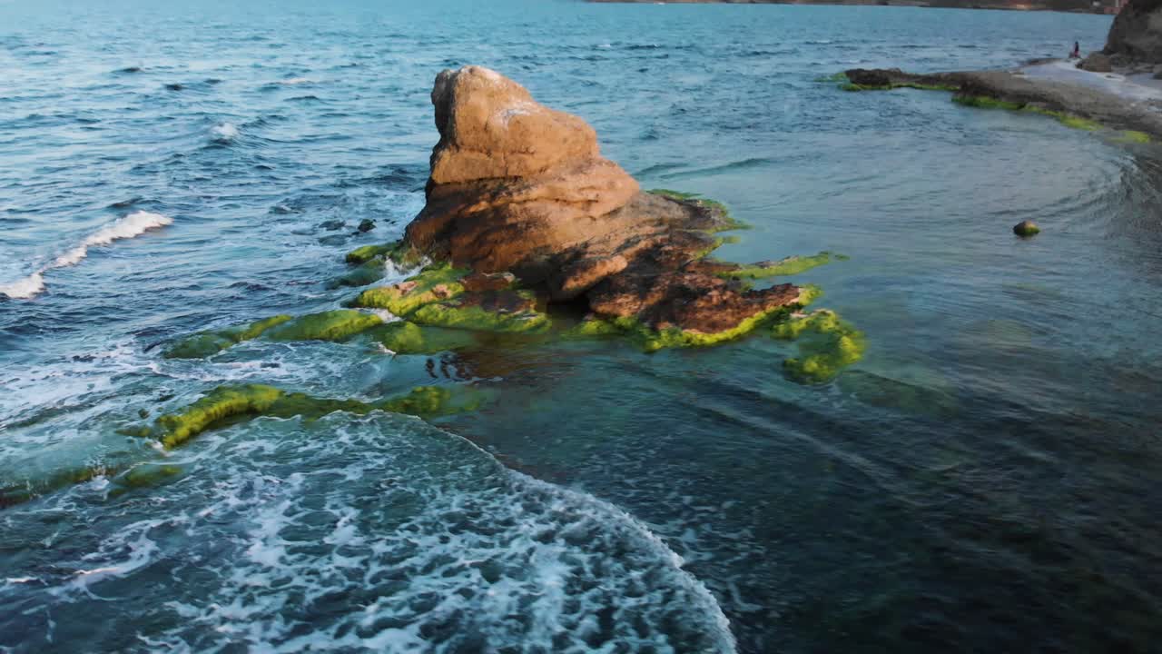 toma aérea dinámica alrededor del acantilado junto a la costa al atardecer