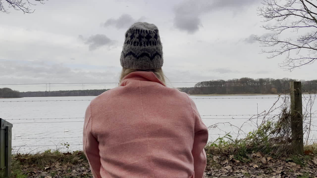 chica de moda joven pensativa sentada en un banco y mirando la naturaleza