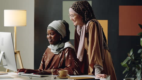 female muslim colleagues chatting in office