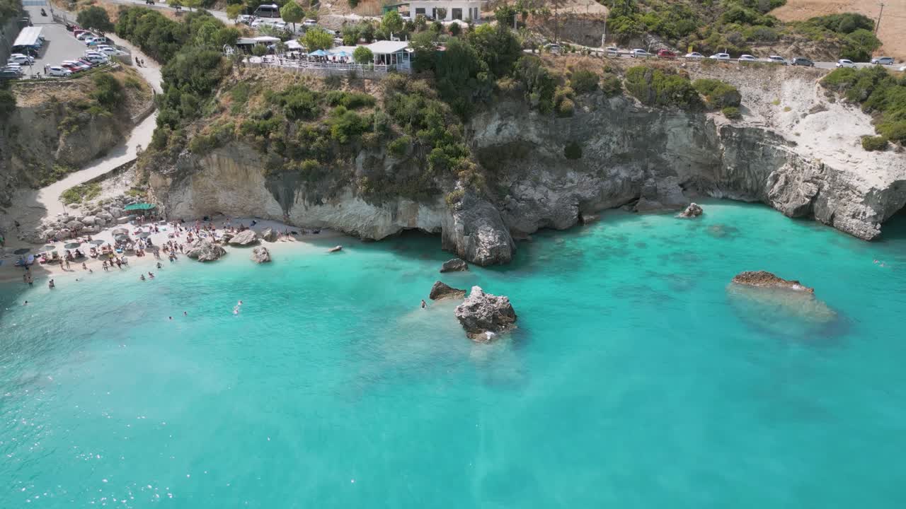 Crystal clear turquoise waters and rocky beach at Zante, Greece, with visitors enjoying