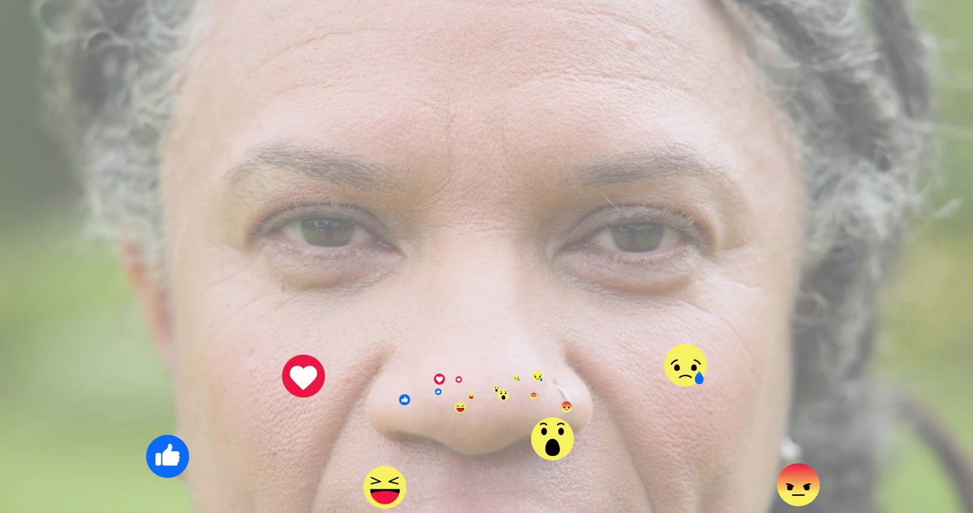 Woman gazing in park as animated icons appearing and swirling on face showing social media feedback
