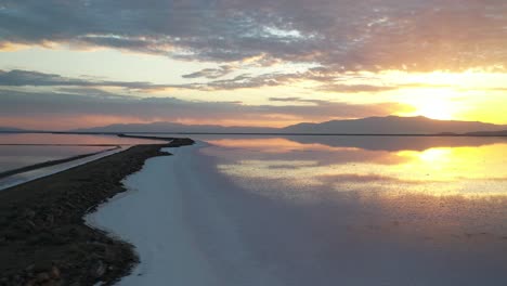 aerial view of magical sunset sunlight above calm water of pink salt lakes, utah usa