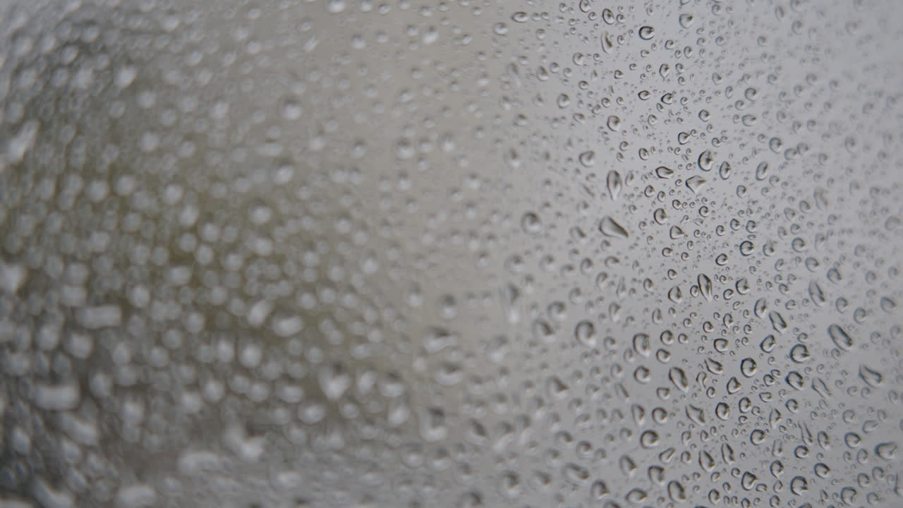 Primo piano di goccioline d'acqua su una superficie di vetro.