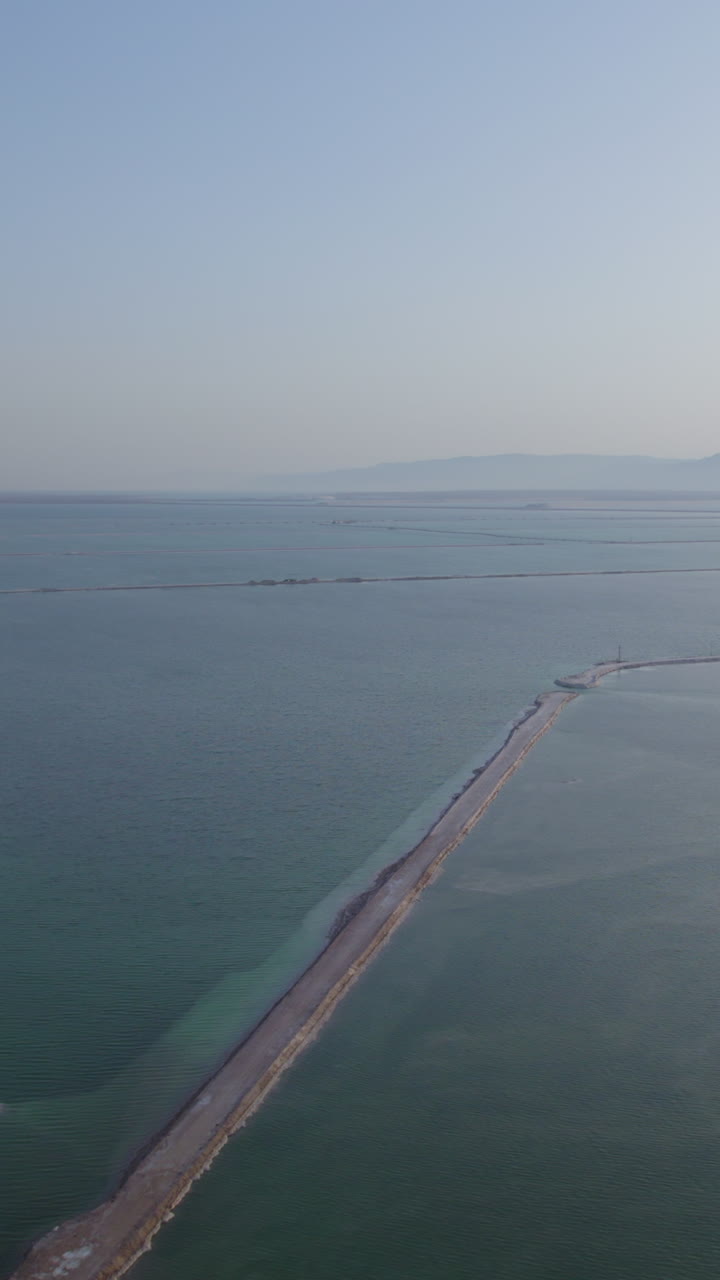 Vertical Slow drone shot over the drainage basins of the Dead Sea with beautiful colors