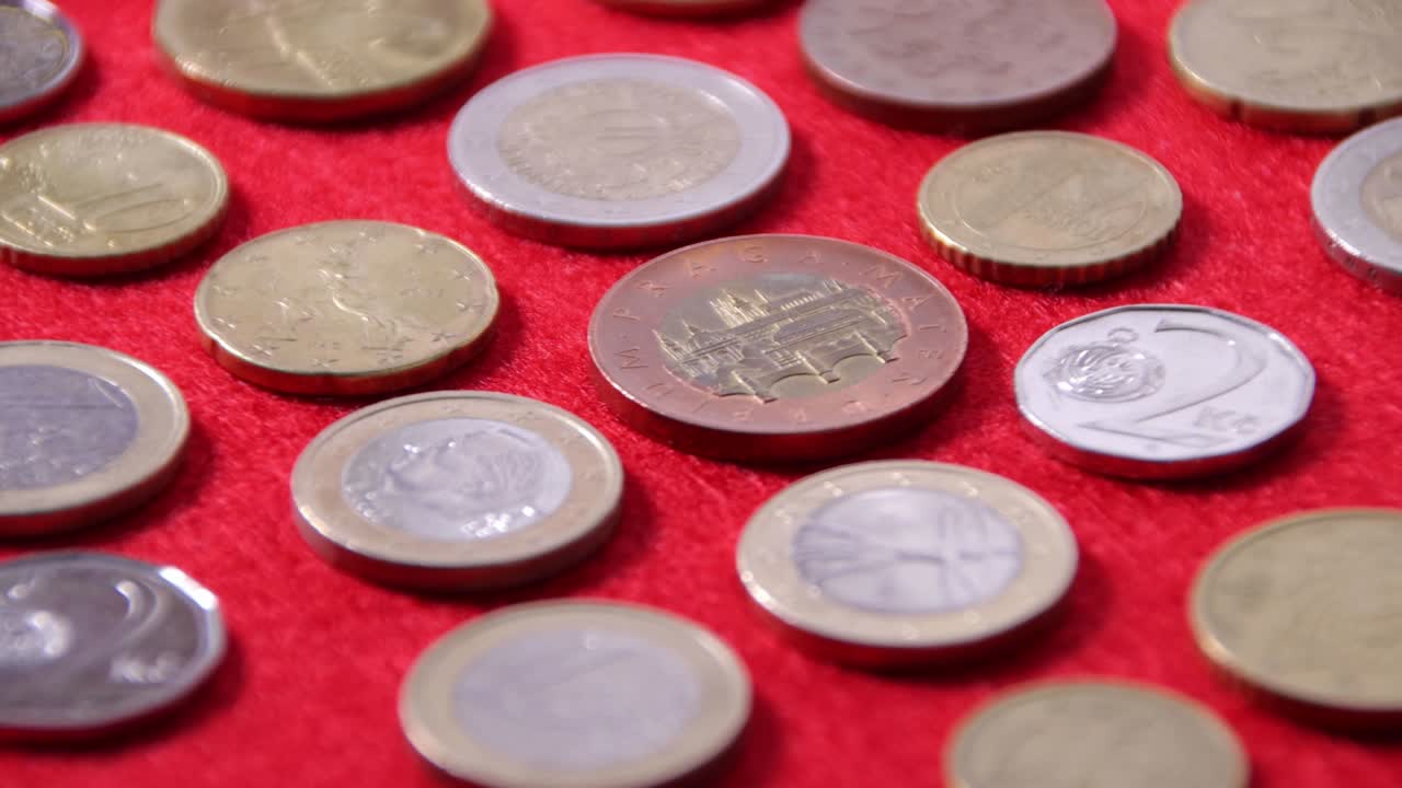 monedas de países europeos en un paño rojo, primer plano, el concepto de ingresos y éxito empresarial.