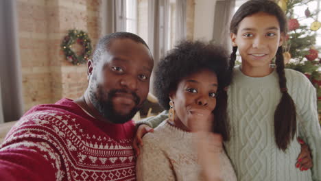 familia afroamericana hablando en la web llamada por el árbol de navidad en casa