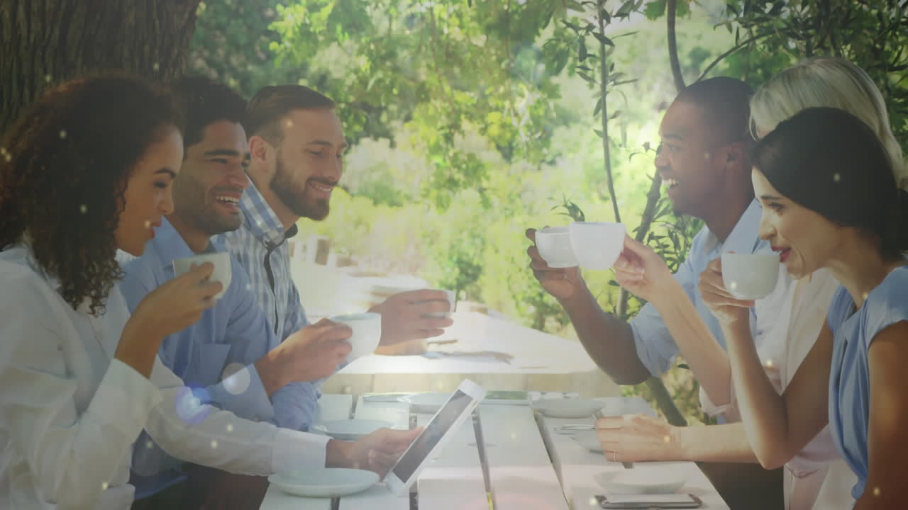 정원에서 함께 커피를 마시는 사람들의 그룹에 대한 빛의 다채로운 반점