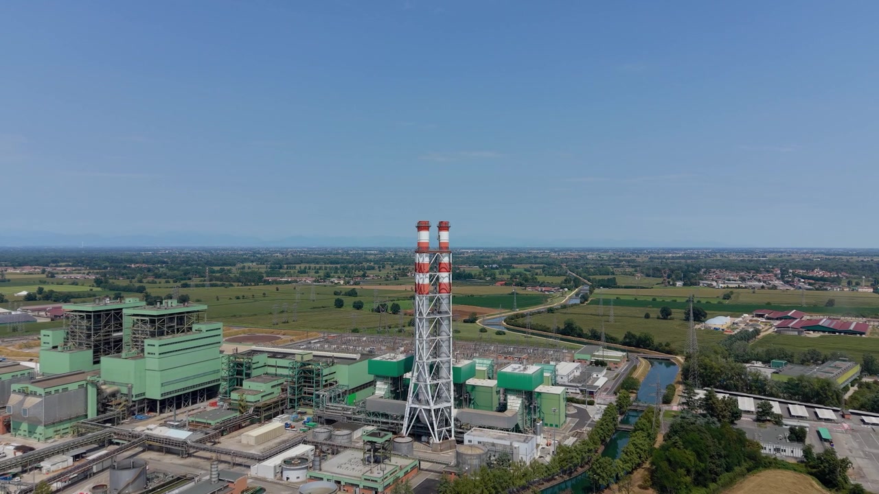 Veduta aerea di una grande centrale elettrica a gas circondata da attrezzature industriali e infrastrutture di supporto, che rappresenta la scala della moderna generazione di elettricità e delle operazioni delle utility.