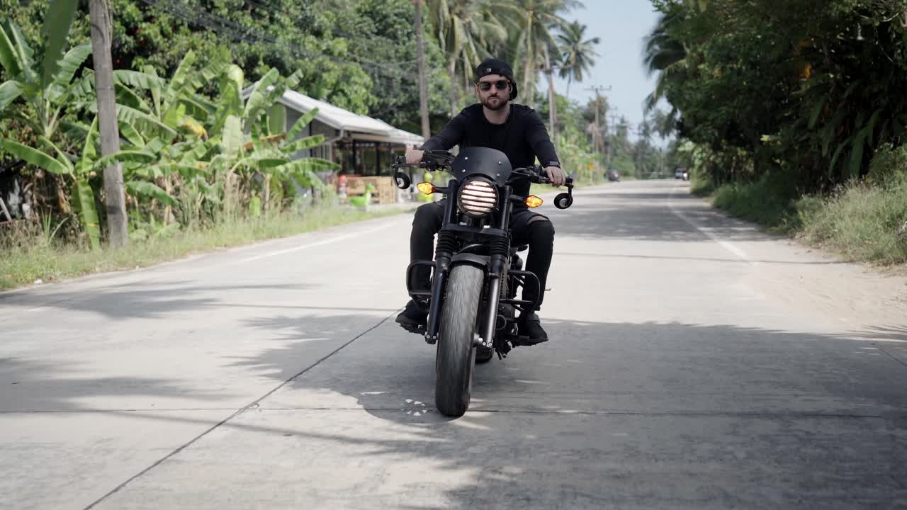 Giovane uomo in moto su una strada tropicale