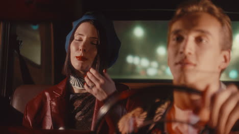 young woman talking to driver during night ride in retro car