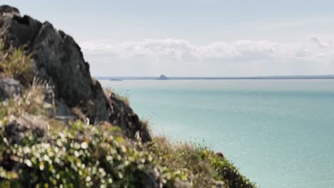 scenic footage captures a breathtaking view of mont saint-michel as seen from the cliffs of carolles in normandy. perched high above the coastline